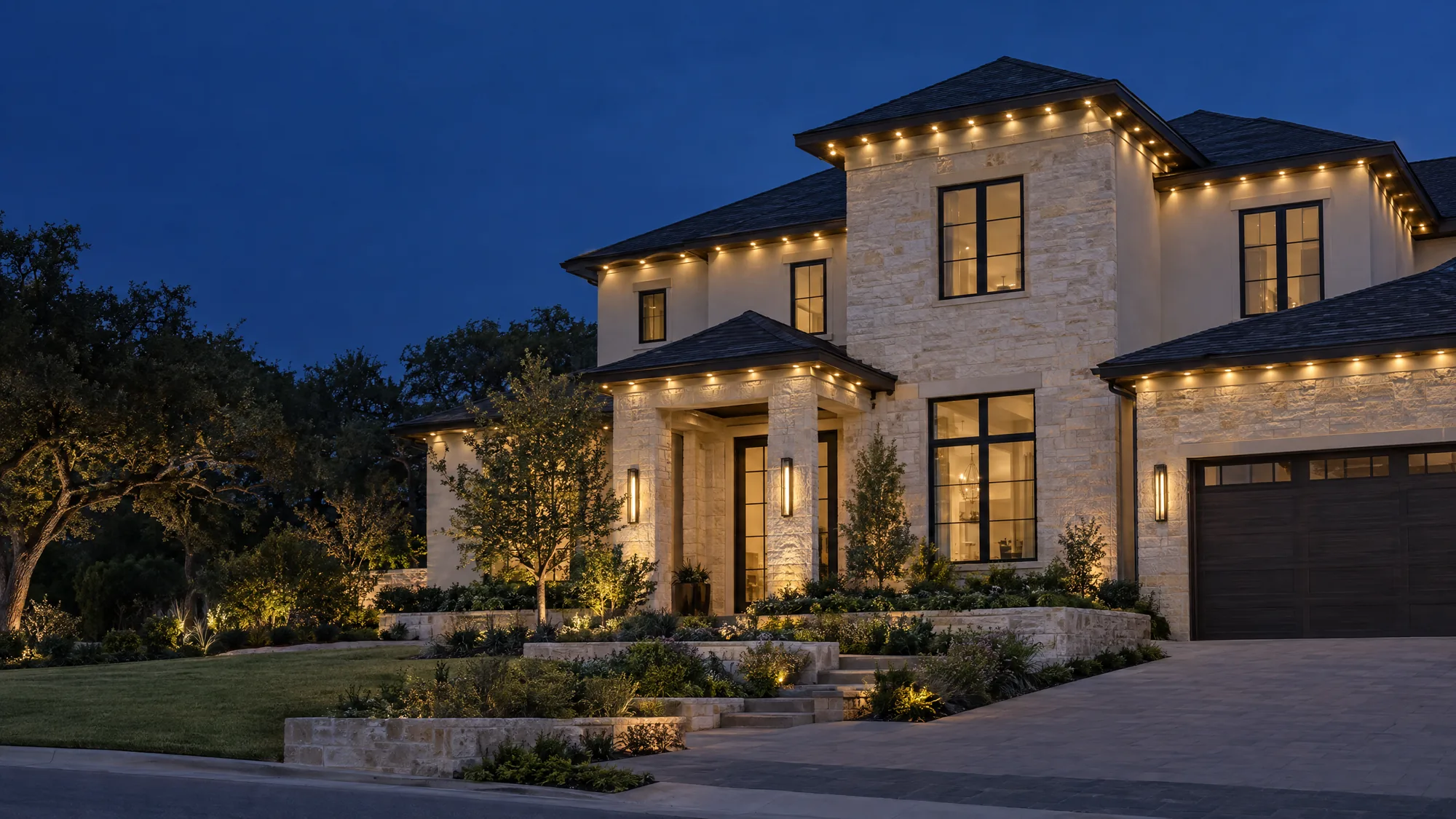 Illustrative warm white roofline lighting on a limestone home at dusk